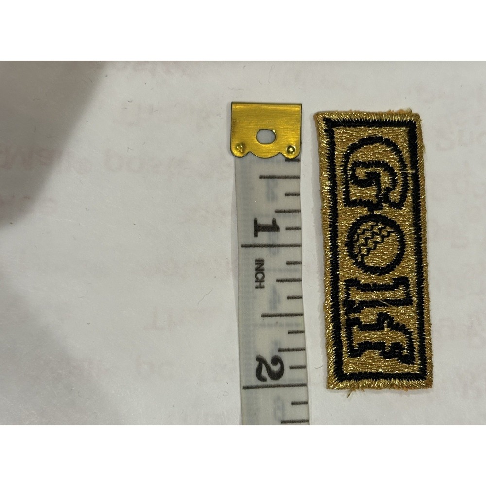 GOLF" in black lettering with a golf ball illustration Iron on or Sewn on Patch